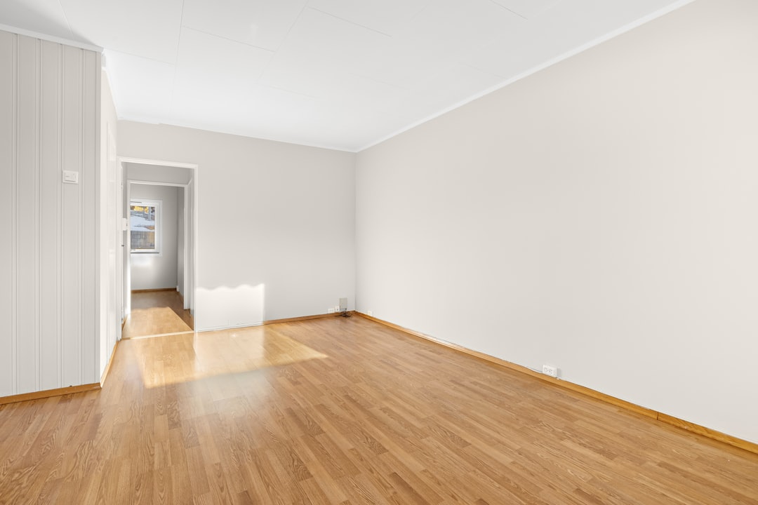 an-empty-room-with-hard-wood-floors-and-white-walls-hckpkwztflw